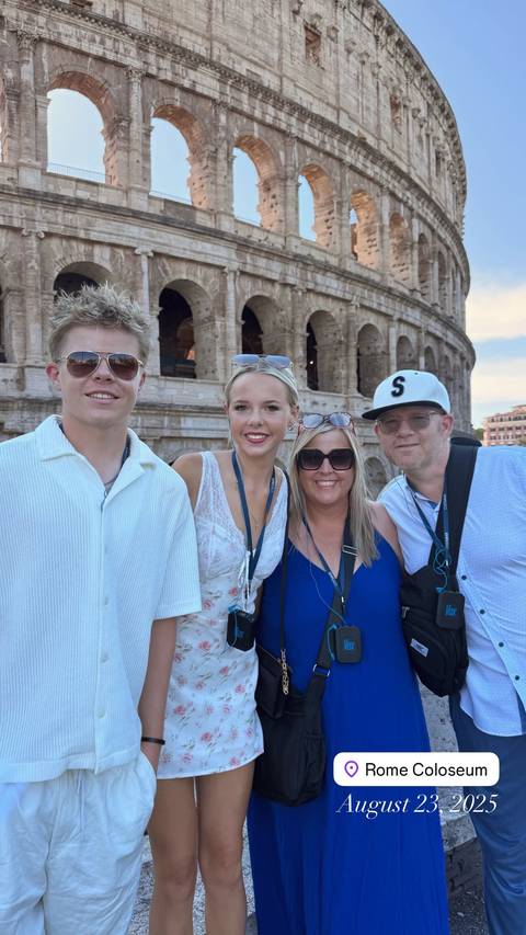 Family posing in front of the Colosseum.