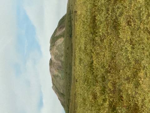       A mountainous landscape under a blue sky.
  