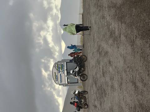       Tourists in colorful raincoats with mountains in the background.
  
