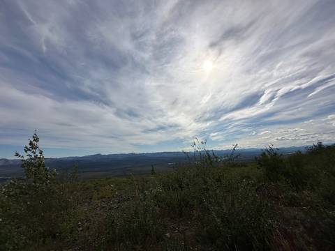       Expansive view of the sky and landscape with sun illuminating the clouds.
  