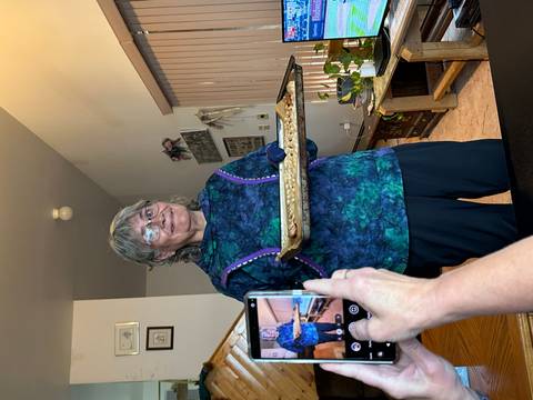       Person holding a tray inside a cozy dining setting.
  
