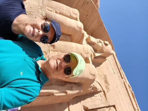 Couple taking a selfie in front of an ancient statue.