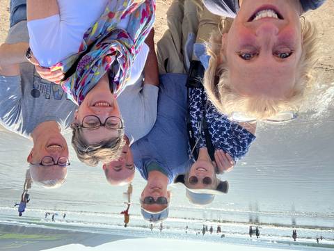       Group of people posing for a selfie on a beach.
  