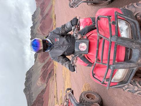Person on an ATV in a colorful mountainous region.