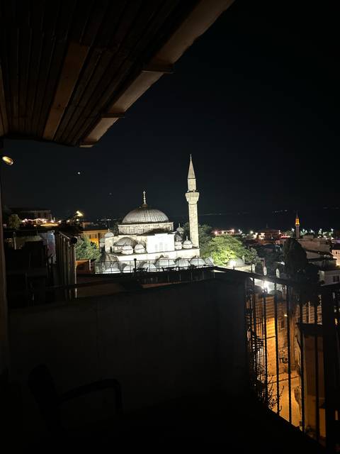       Night view of a mosque with lights in a Turkish cityscape.
  