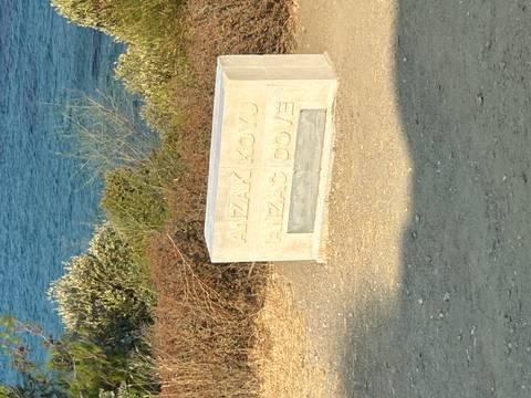       Sign for Anzac Cove with a scenic view.
  
