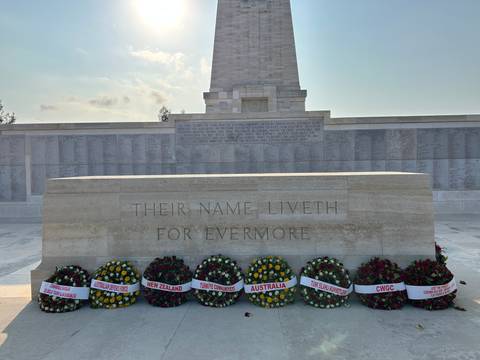      A war memorial with wreaths laid in front.
  