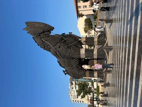       Replica of the Trojan Horse with tourists nearby.
  