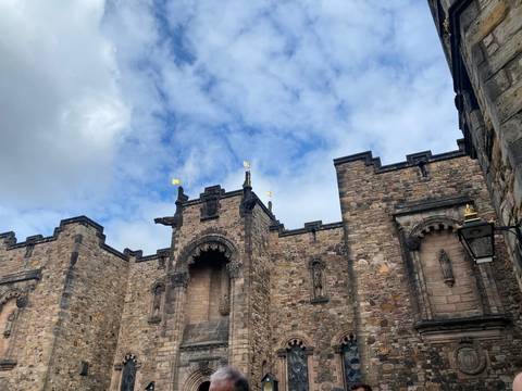 Close-up of a stone building with decorative details and blue sky.