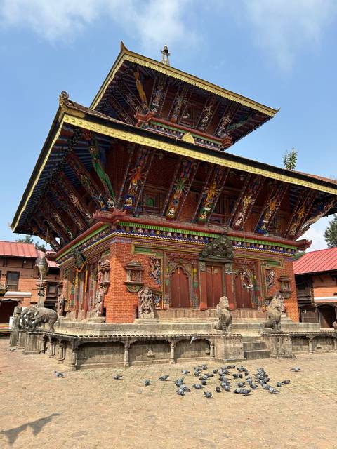       Ornately decorated temple with red brick and intricate details.
  