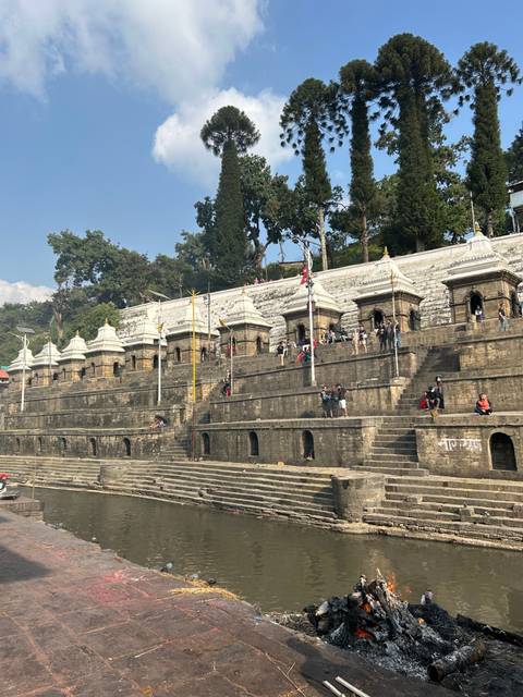       Visitors and stone monuments at a historical site with steps.
  