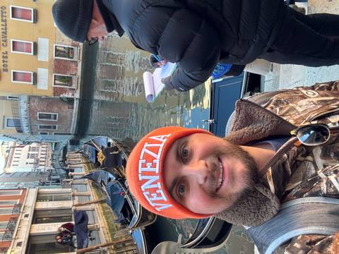Selfie of a person in front of Venetian canals and gondolas.