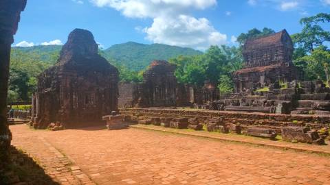       Ruins of ancient structures with mountains in the background.
  