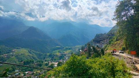       Scenic view of a valley with mountains and rural houses.
  