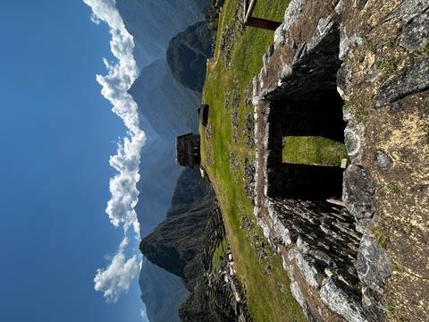       Panoramic view of Machu Picchu's ruins and mountains.
  