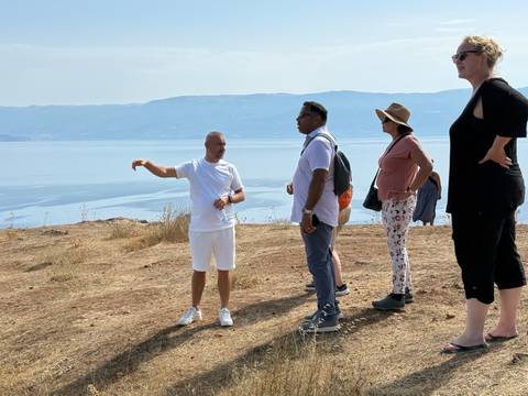 Group of people standing by a body of water.