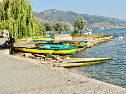 Colorful boats docked on a lakeshore.