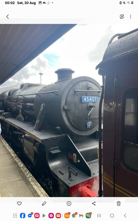 Vintage steam locomotive engine parked at a station.