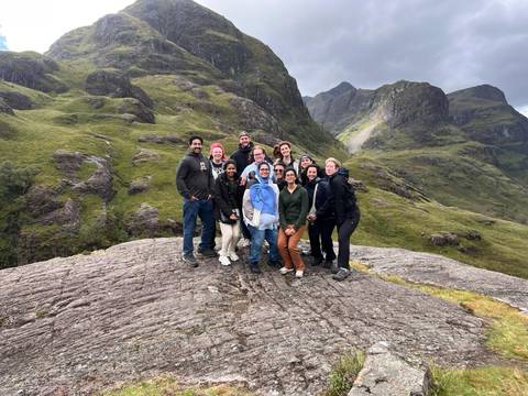       Group of people posing on rocks in a mountainous area.
  