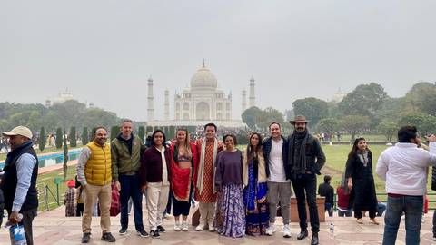       Group of people in front of the Taj Mahal.
  