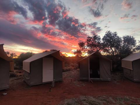       Tents at a campsite during a vibrant sunset.
  