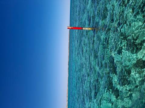 Clear turquoise waters with a solitary pole.