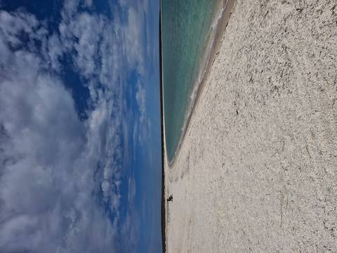 Empty beach with clear sky and calm waters.