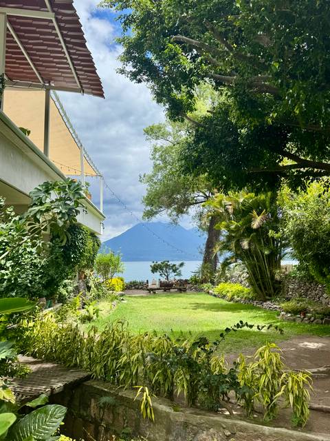 Lush garden with a view of a distant mountain and lake.