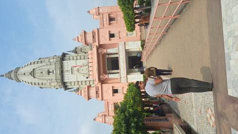 Man walking towards a temple with a tall spire.