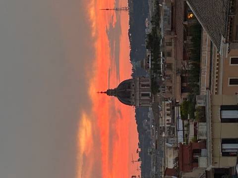 City skyline during sunset featuring a dome.