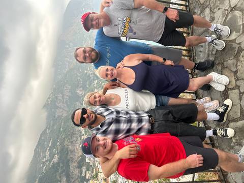 Group of people smiling with a coastal view.