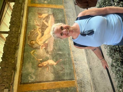Woman standing in front of an ancient fresco.