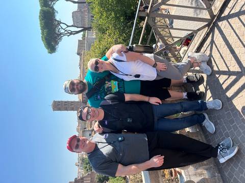Group of tourists posing on a terrace with a city view.