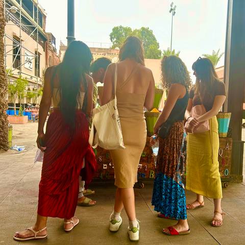       Group of people shopping at a market stall.
  