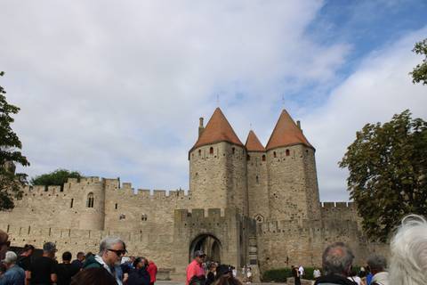 Historical fortress walls and towers with people around.