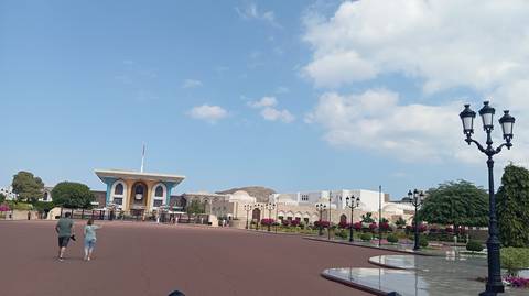 Palatial building complex with people strolling around.