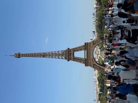 A bustling tourist scene with the Eiffel Tower in the background.