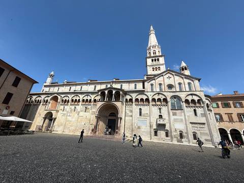 A large historic cathedral in a public square with people around.