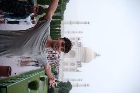       Person in front of the Taj Mahal posing with arms spread.
  