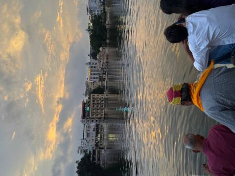       People sitting by a lake during a sunset.
  