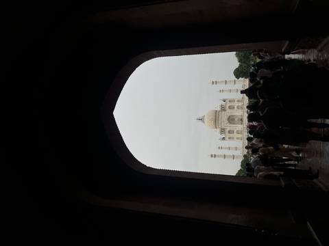       Crowd viewing the Taj Mahal from an arched entrance.
  