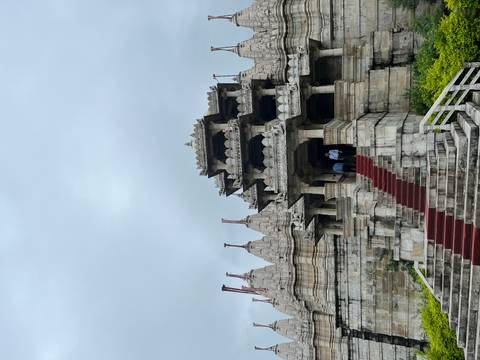       Intricate stone temple entrance with red stairs and carvings.
  