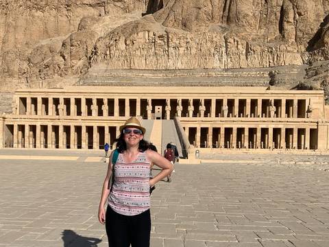       Tourist posing in front of an Egyptian temple.
  