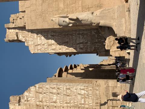 Large temple ruins with tourists observing.