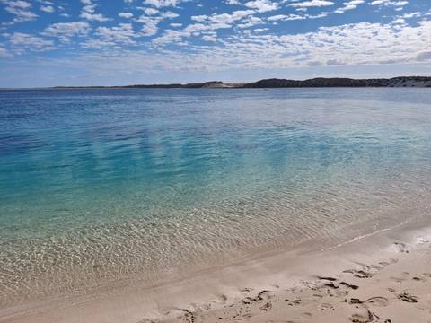 Crystal clear turquoise waters along a sandy beach.