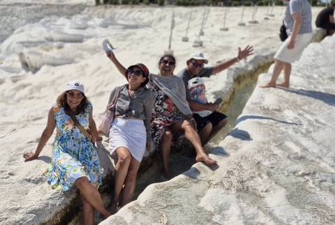       Group of people posing on white travertine terraces.
  