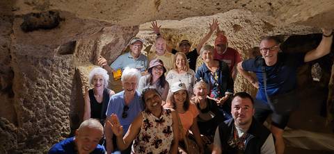       Group of people in an underground cave structure.
  
