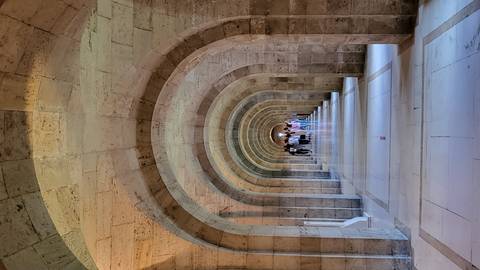       Concrete hallway with a series of archways leading to the distance.
  