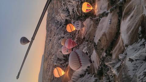       Hot air balloons floating over the rocky terrain of Cappadocia.
  