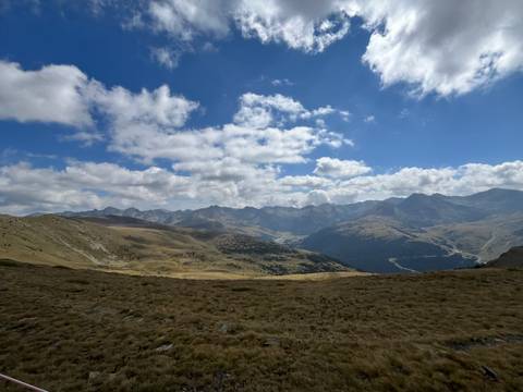       Mountainous landscape with a vast valley under a partially cloudy sky.
  
